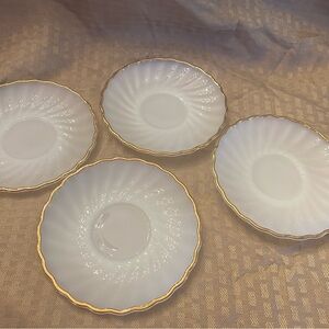 Set of four vintage Fire King milk glass swirl saucers with gold trim.